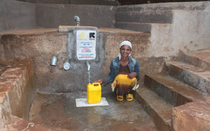 local woman at a spring protection system